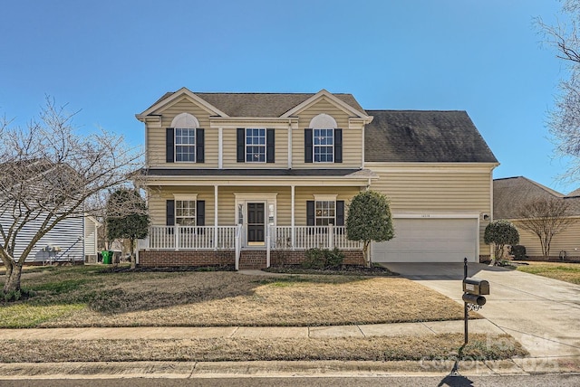 view of front of home with a garage, a front lawn, and covered porch