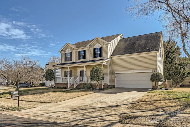 view of property with a garage, covered porch, and a front lawn