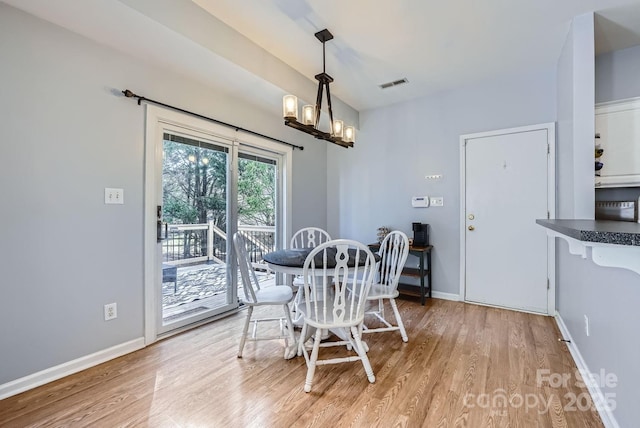 dining area with a chandelier and light hardwood / wood-style floors