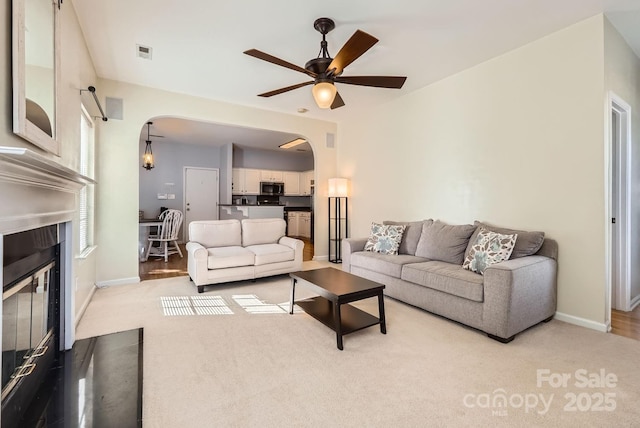 carpeted living room featuring ceiling fan