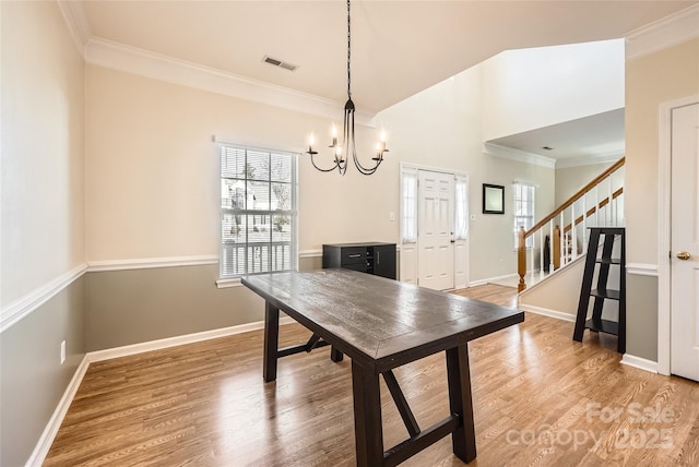 unfurnished dining area featuring a notable chandelier, wood-type flooring, and ornamental molding