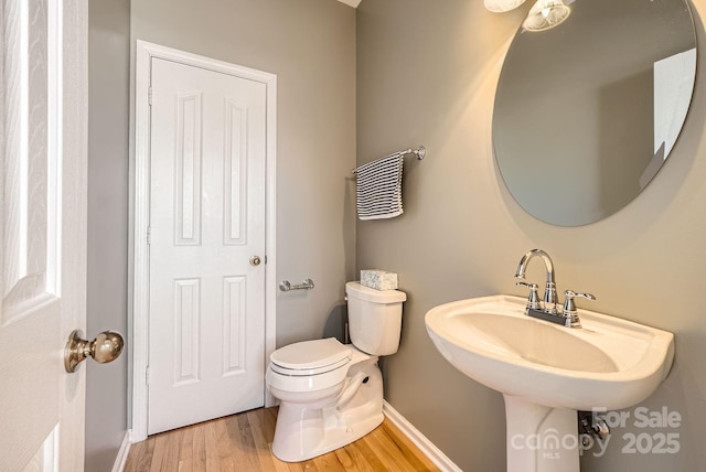 bathroom featuring wood-type flooring, sink, and toilet