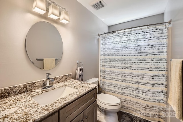 bathroom featuring vanity, toilet, and curtained shower