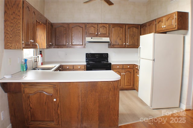 kitchen with light hardwood / wood-style flooring, white refrigerator, black / electric stove, kitchen peninsula, and ceiling fan