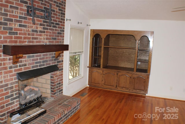 unfurnished living room with hardwood / wood-style floors and a fireplace