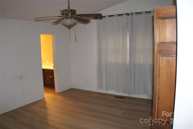 empty room with ceiling fan and light hardwood / wood-style flooring