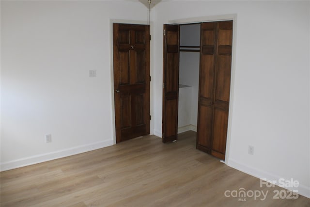 unfurnished bedroom featuring light hardwood / wood-style floors and a closet