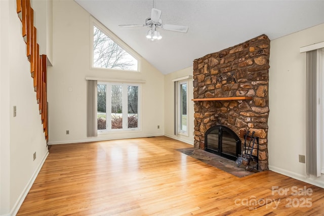 unfurnished living room featuring a fireplace, high vaulted ceiling, ceiling fan, and light wood-type flooring