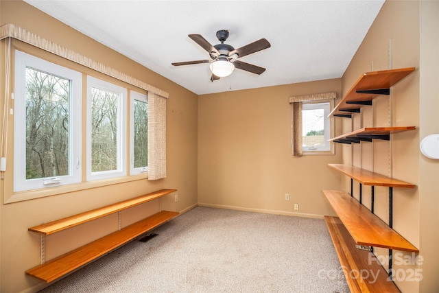 unfurnished room featuring ceiling fan and carpet