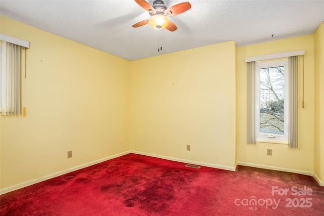 carpeted empty room with a textured ceiling and ceiling fan