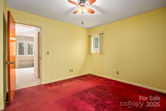 carpeted empty room featuring ceiling fan and a textured ceiling