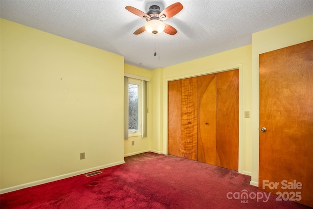 unfurnished bedroom with ceiling fan, carpet floors, a closet, and a textured ceiling