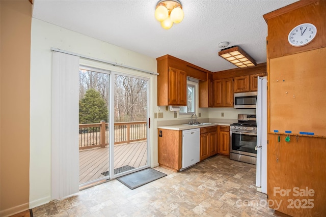 kitchen featuring stainless steel appliances, sink, and a textured ceiling