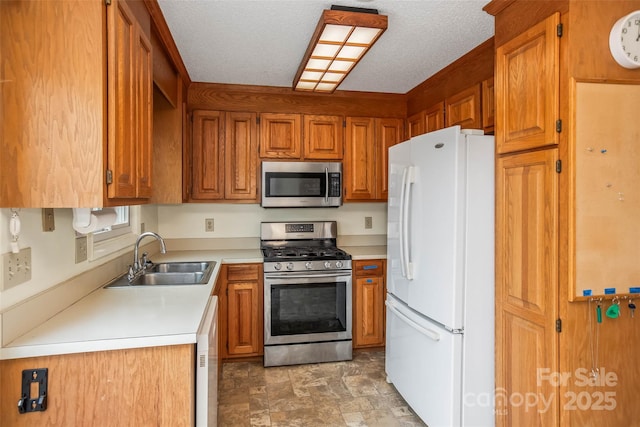 kitchen featuring stainless steel appliances, sink, and a textured ceiling