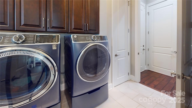 laundry area with light tile patterned floors, cabinet space, and washing machine and dryer