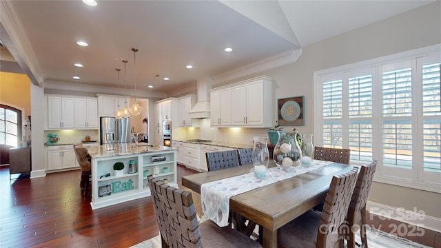 dining space with sink, crown molding, dark wood-type flooring, and vaulted ceiling