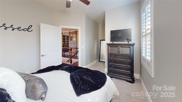 carpeted bedroom with ceiling fan and a barn door