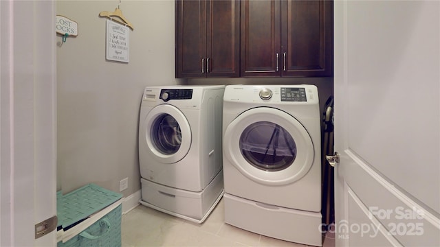 laundry area featuring cabinets, washer and dryer, and light tile patterned floors