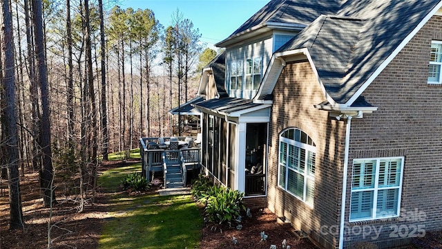 view of home's exterior with a yard, a sunroom, and a deck