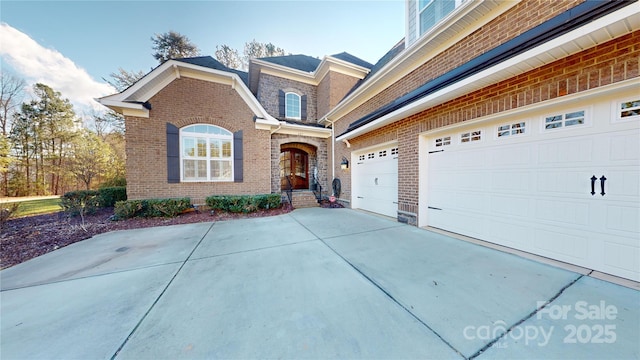 view of front of home featuring driveway and brick siding