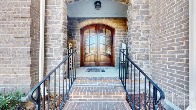 property entrance with brick siding and french doors