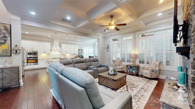 living room with dark wood-style flooring, visible vents, beamed ceiling, ceiling fan, and coffered ceiling