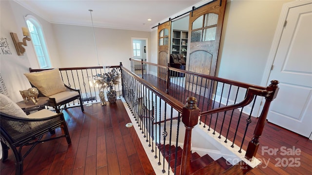 stairs with wood-type flooring, crown molding, a barn door, and recessed lighting