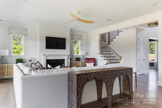 living room featuring hardwood / wood-style flooring, ceiling fan, and plenty of natural light