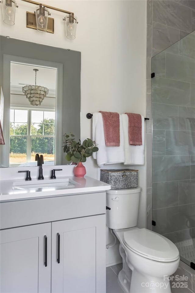 bathroom featuring vanity, a tile shower, and toilet