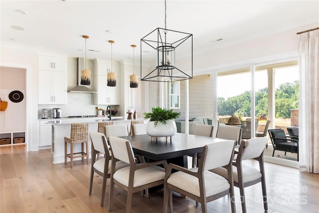 dining area featuring crown molding and light hardwood / wood-style floors