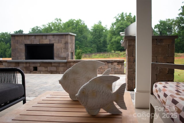 view of patio with an outdoor stone fireplace