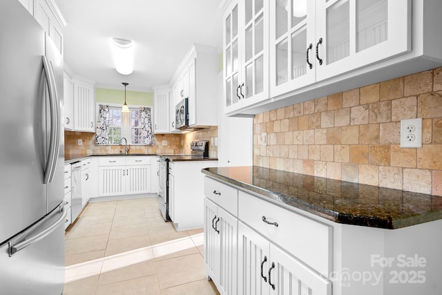 kitchen with stainless steel appliances, light tile patterned flooring, white cabinets, and decorative light fixtures