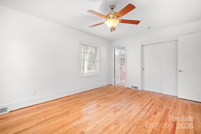 unfurnished bedroom featuring ceiling fan, a closet, and light wood-type flooring