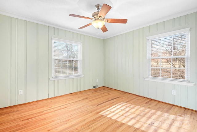 empty room featuring crown molding, light hardwood / wood-style flooring, and ceiling fan