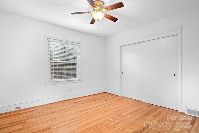 unfurnished bedroom with hardwood / wood-style flooring, a closet, and ceiling fan