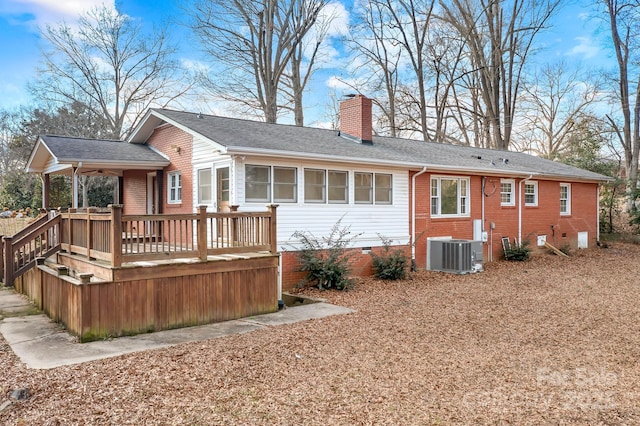 rear view of property featuring a wooden deck and central AC unit