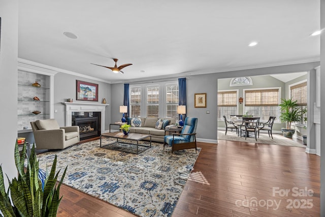 living room with hardwood / wood-style flooring, ornamental molding, and a healthy amount of sunlight