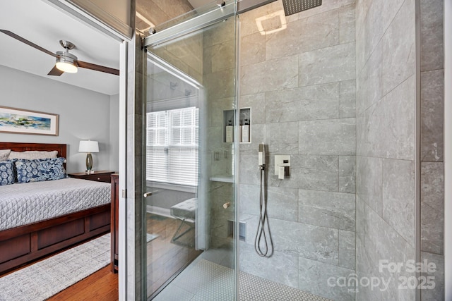 bathroom with ceiling fan, wood-type flooring, and a shower with door