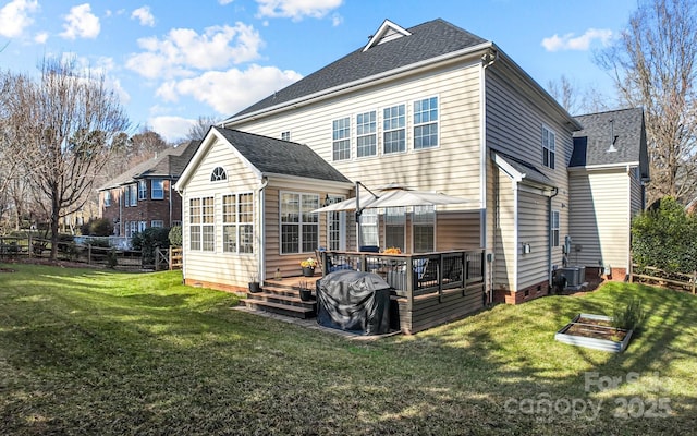 back of property with a deck and a lawn