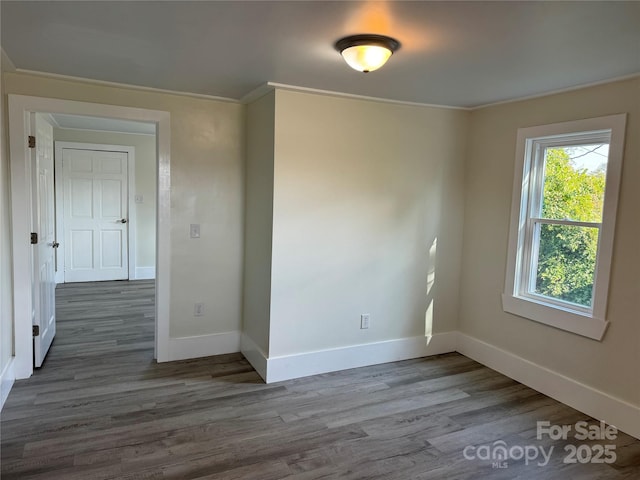 unfurnished room with ornamental molding and dark hardwood / wood-style floors