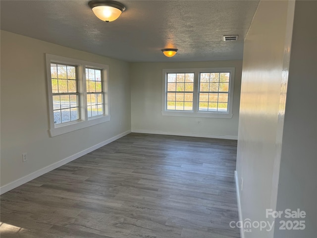 empty room featuring dark hardwood / wood-style floors and a textured ceiling