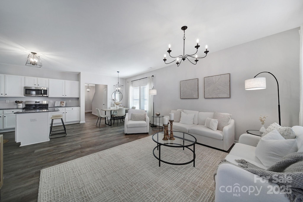 living room featuring an inviting chandelier and dark hardwood / wood-style flooring