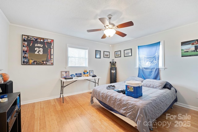 bedroom featuring crown molding, wood-type flooring, a textured ceiling, and ceiling fan