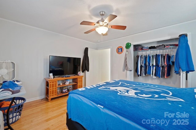 bedroom with hardwood / wood-style flooring, ornamental molding, a closet, and ceiling fan