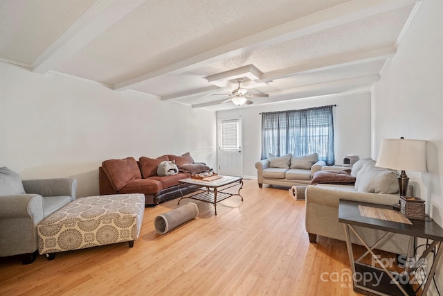 living room with hardwood / wood-style flooring, ceiling fan, a textured ceiling, and beam ceiling