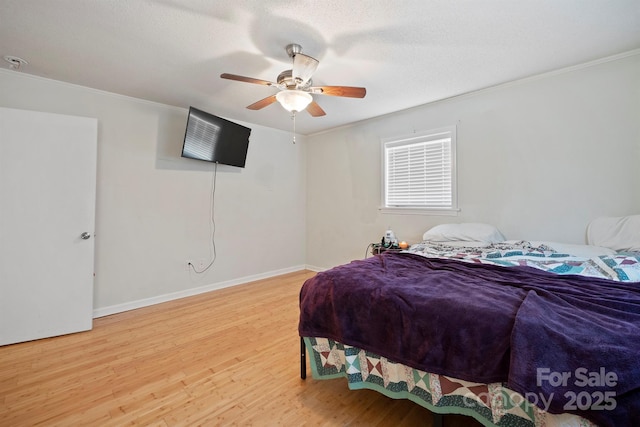 bedroom with hardwood / wood-style floors, a textured ceiling, ornamental molding, and ceiling fan