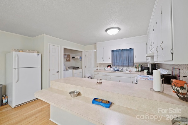 kitchen featuring sink, white cabinets, white fridge, washer and clothes dryer, and light hardwood / wood-style flooring