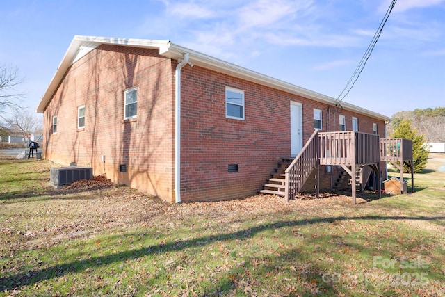 rear view of house featuring central AC, a lawn, and a deck