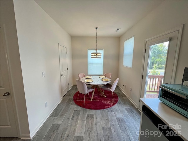 dining space with wood-type flooring