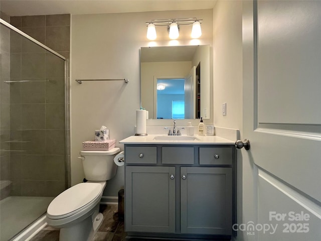 bathroom featuring vanity, an enclosed shower, and toilet